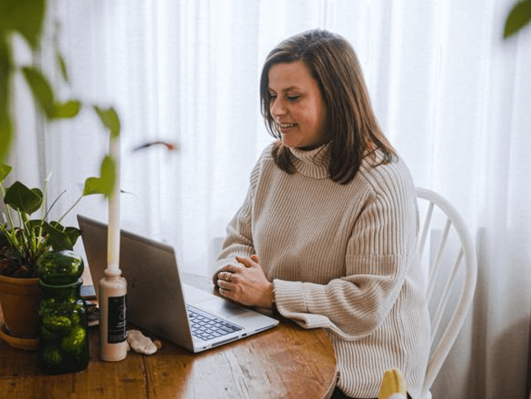 Vrouw zit achter een laptop en bekijkt informatie over vaste, variabele en dynamische energiecontracten.
