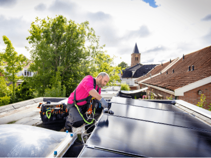 Monteur installeert zonnepanelen op een woonhuisdak