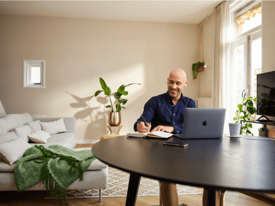 Man zit aan tafel en vult online huisscan in op laptop