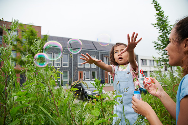 Meisje en vrouw zitten blazen te bellen.