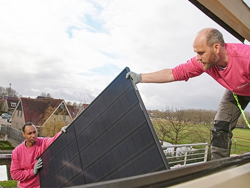 Twee monteurs installeren zonnepaneel