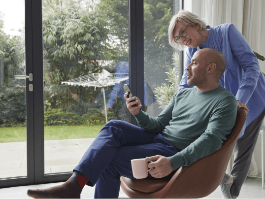 Man en vrouw bekijken subsidie warmtepompen op mobiel