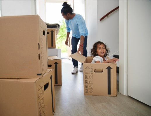 Kind zit in een verhuisdoos.