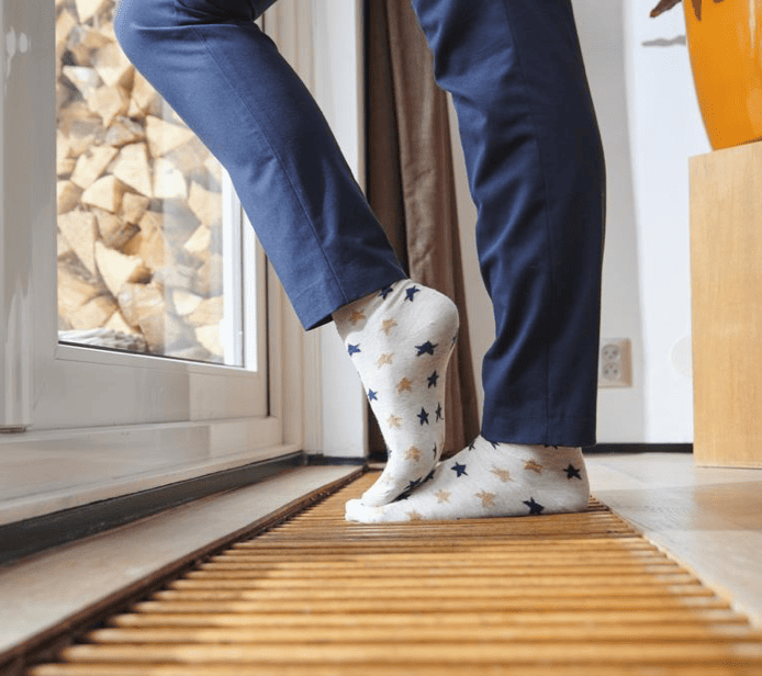 Iemand staat op een vloerconvector rooster