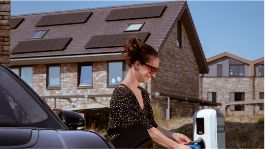 Vrouw in nieuwbouwwijk doet aan elektrisch laden