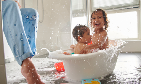 Twee peuters zijn aan het spelen in bad