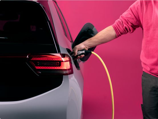 Man laadt elektrische auto op met laadpaal thuis.