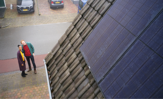 Mensen kijken naar het dak met zonnepanelen.