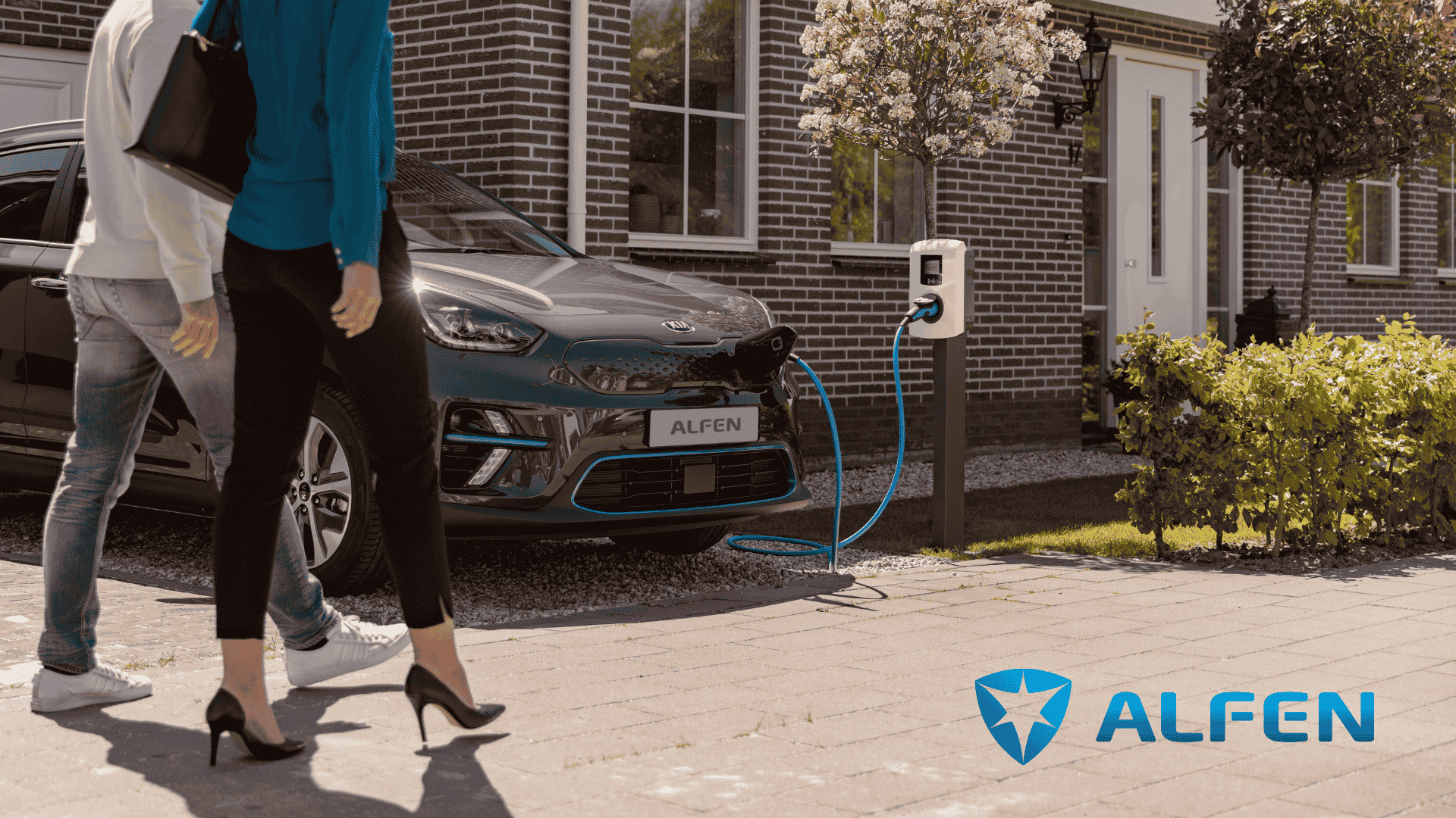 Man en vrouw lopen langs auto die oplaadt bij Alfen laadpaal.