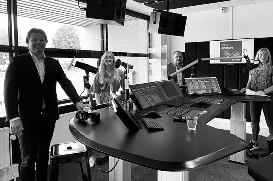 Vier mensen zitten in een studio te vergaderen over een eerlijke en transparante energieverkoop