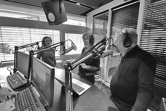 Drie mensen praten over incasseren in een studio.