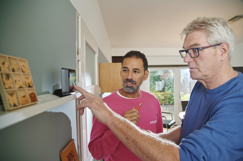 Twee mannen kijken naar de thuisbatterij
