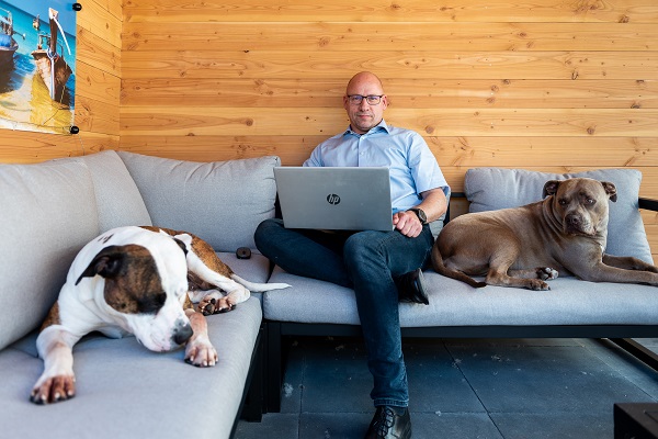 Alex Principaal thuis op de bank met laptop en hond