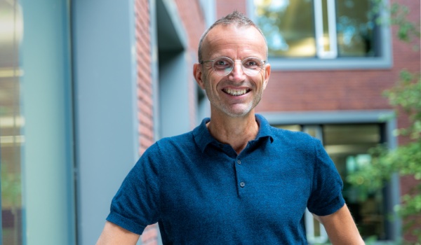 Man met donker blauwe shirt lacht.