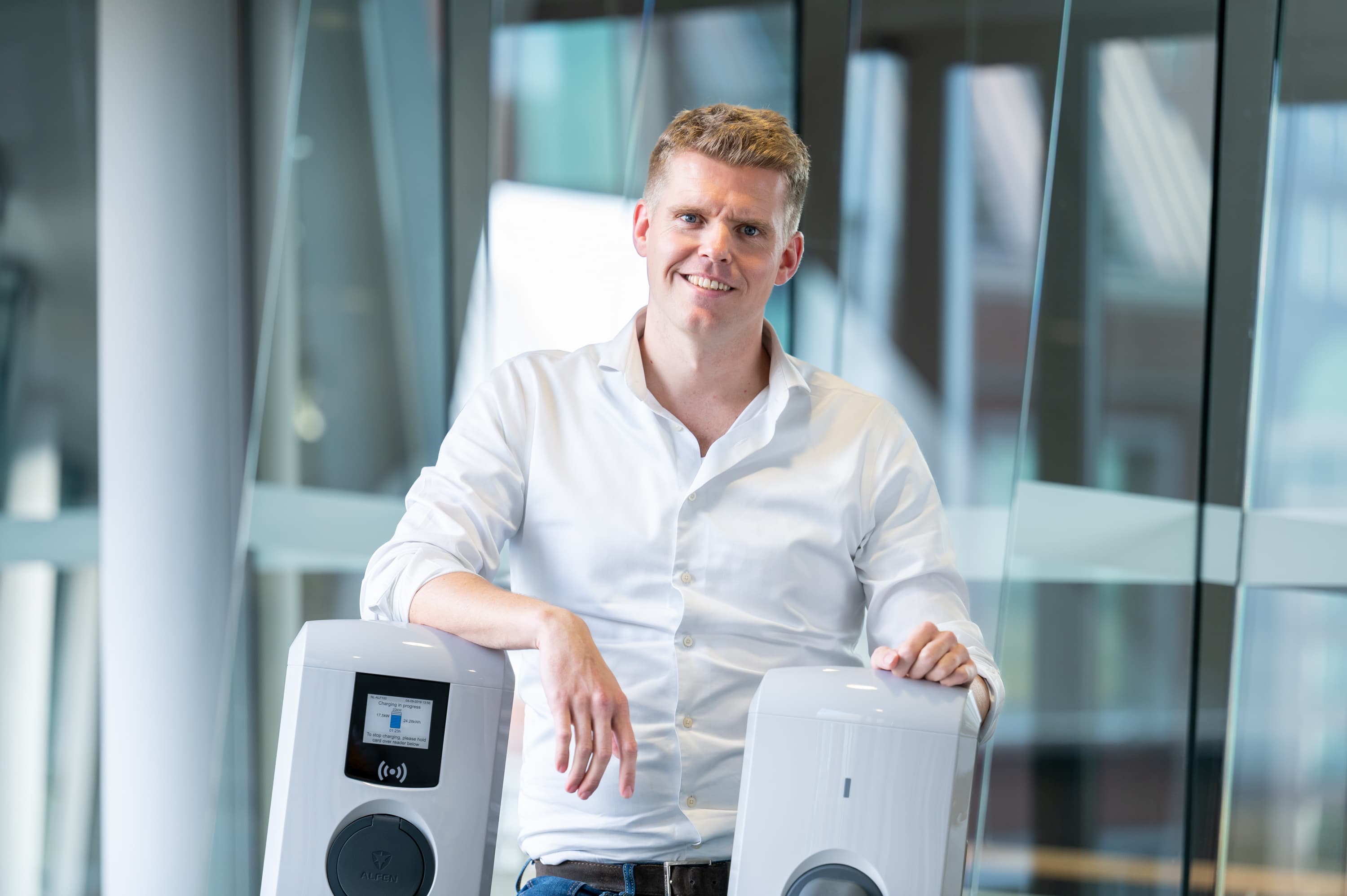 Daan Hermans van E-Mobility staat bij een laadpaal.