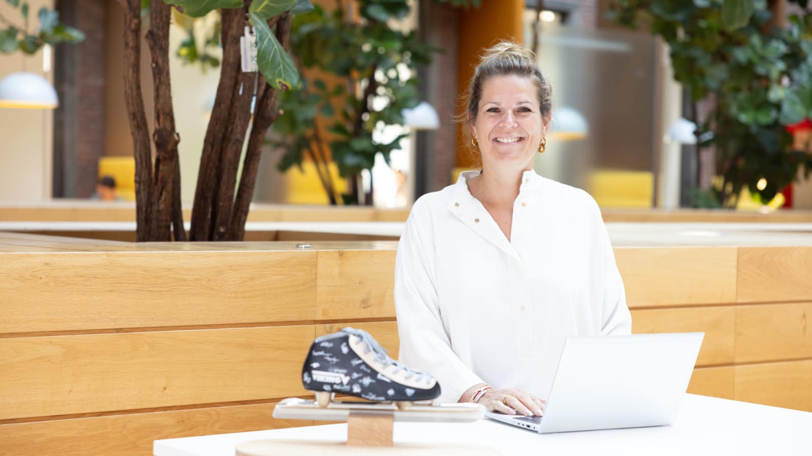 Manager New Business & Partnerships Bianca Bremmer staat aan tafel met laptop en schaats.