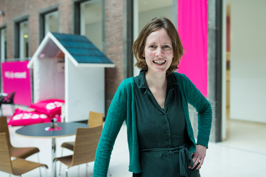 Vrouw met groen shirt lacht.