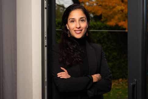 Vrouw met zwart kleding aan kijkt naar ons.