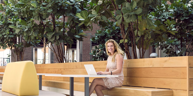 Vrouw glimlacht en werkt met een netwerk van privacy champions.